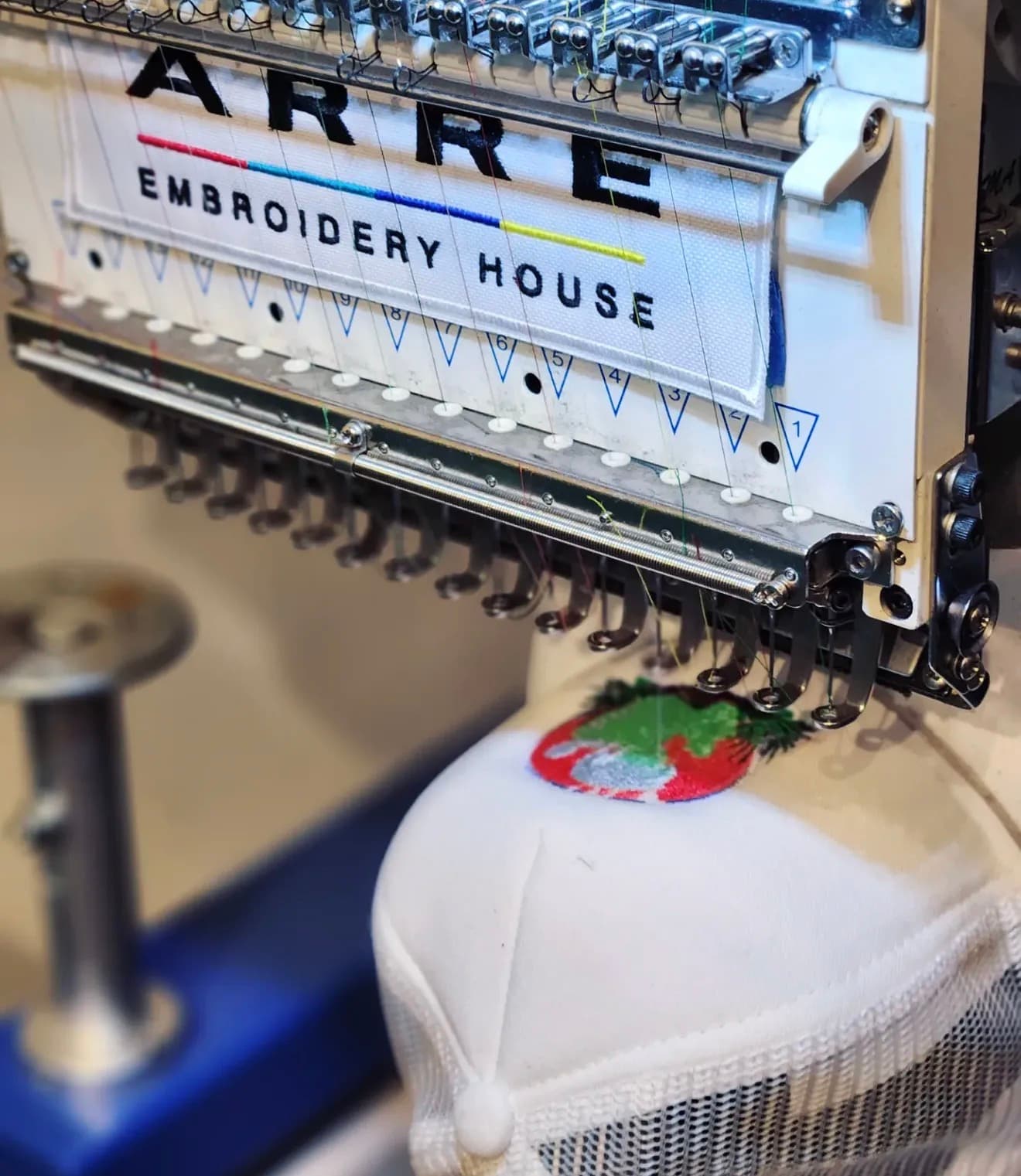 ARRE machine stitching a patch onto a white cap